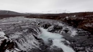 İzlanda 'da karlı ve güzel manzaralı bir şelale manzarası.