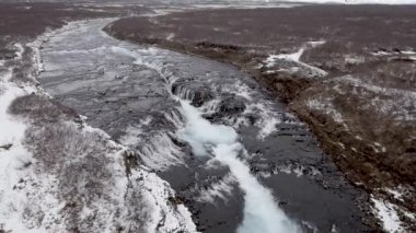 İzlanda 'da karlı ve güzel manzaralı bir şelale manzarası.