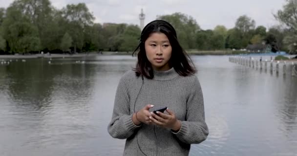 Autentický záběr krásné mladé ženy relaxující v parku na jaře — Stock video