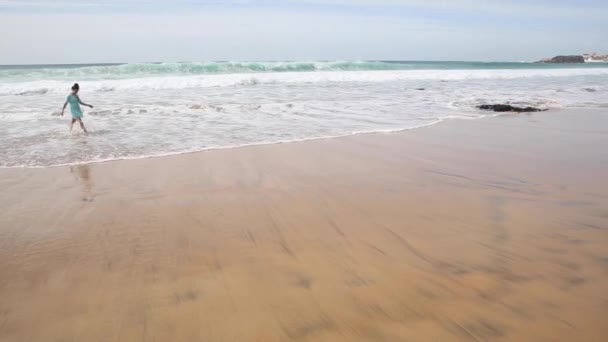 Hermosa mujer sola en la playa caminando y salpicando agua en Fuerteventura — Vídeo de stock