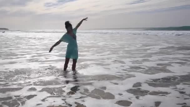 Belle femme seule au bord de la mer marchant et éclaboussant l'eau à Fuerteventura — Video