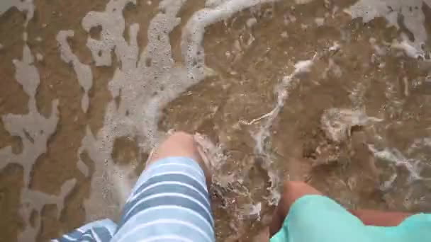 Vista superior de alguns pés andando na areia à beira-mar — Vídeo de Stock