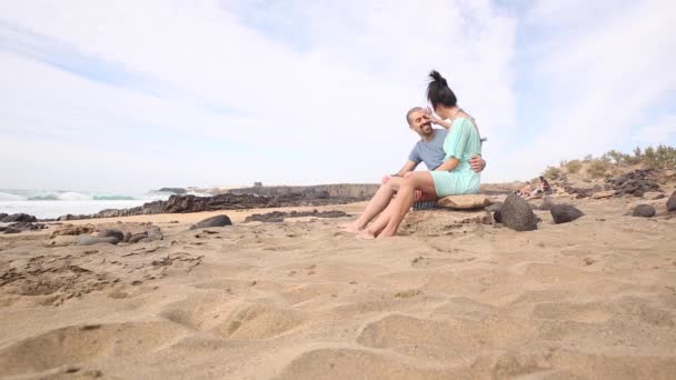 Auténtica toma de una joven pareja enamorada pasando tiempo juntos en la playa — Vídeo de stock