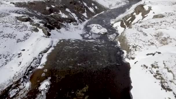 Вид с воздуха на водопад в Исландии со снежным красивым ландшафтом — стоковое видео