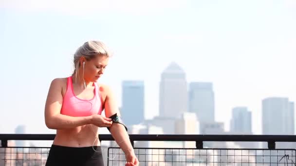 Жінка налаштувала фітнес-трекер перед тренуванням і бігом по місту — стокове відео