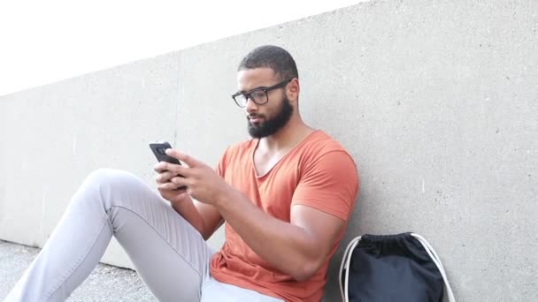 Siyah Adam Oturuyor Telefonda Yazıyor Sakallı Gözlüklü Yakışıklı Şehirde Beton — Stok video