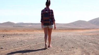 Happy woman walking in the desert in Fuerteventura - Modern digital nomad enjoying lifestyle in new normal life and exploring the island on a sunny day