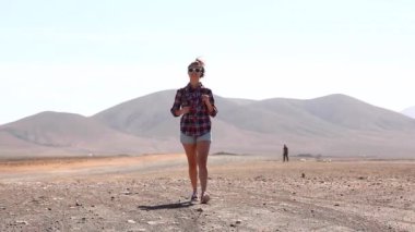 Happy woman walking in the desert in Fuerteventura - Modern digital nomad enjoying lifestyle in new normal life and exploring the island on a sunny day