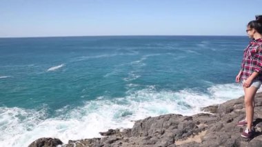 Authentic shot of a young woman at seaside enjoying the view of the ocean on a sunny day in Fuerteventura - Travel and lifestyle concepts