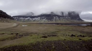 Winter landscape in Iceland on a cloudy day with mountains on background in a typical Icelandic view. Travel and wild nature concepts