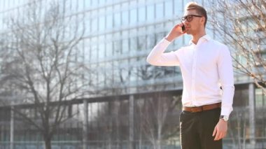 Authentic shot of a business man in the city talking on the phone and taking a break from office work in London on a sunny day