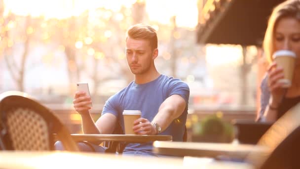 런던에 카페에서 남자와 여자가 커피를 마시고 스마트폰 디지털 태블릿을 사용하여 — 비디오