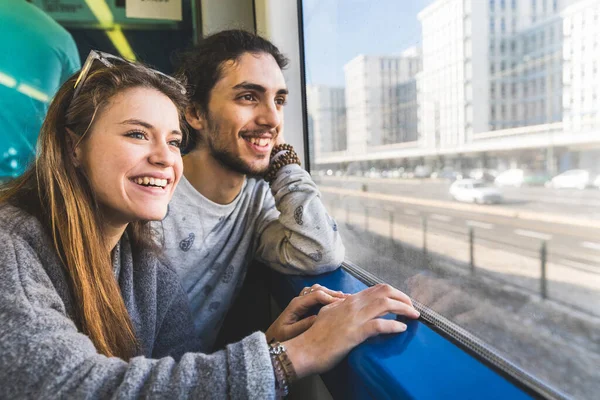 ポルトガルの晴れた日に一緒に休暇で一緒に旅行中に電車の窓から外を見ている幸せなカップル 笑顔の若い男性と女性 右側のコピースペース — ストック写真