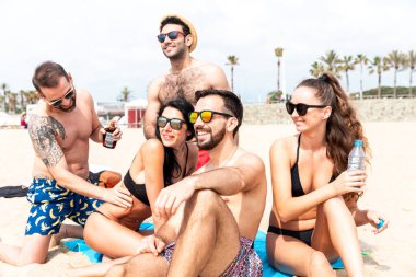 Barcelona 'da plajda dinlenen mutlu insanlar, çok ırklı en iyi arkadaşlar yaz tatilinin tadını çıkarıyorlar, eğleniyorlar, İspanya' ya seyahat ederken mutluluk ve dostluk.