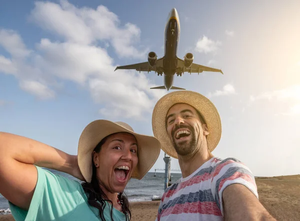 在西班牙的暑假里 一对快乐的夫妇在机场自拍 飞机在他们身后着陆 一边笑着看镜头 一边玩乐 度假和生活方式的概念 — 图库照片