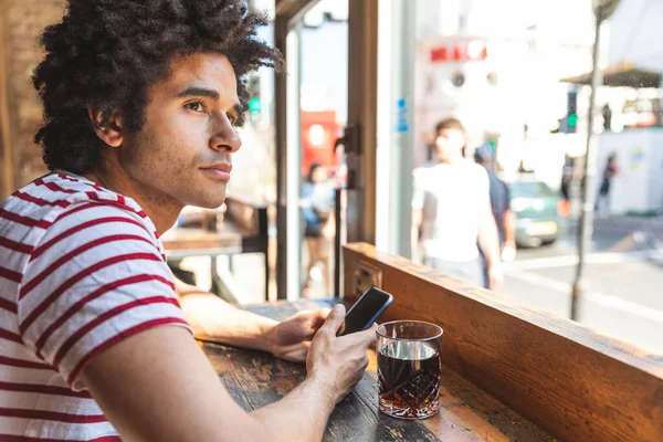 Pensativo Hombre Multirracial Beber Refrescos Uso Teléfono Bar Cafetería Joven — Foto de Stock