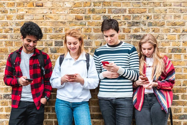 Londra 'da cep telefonu kullanan ve arayan bir grup genç öğrenci - sosyal medya ve internet bağımlısı en iyi arkadaşlar - Londra' da yaşam tarzı ve arkadaşlık