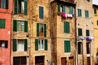 Ortaçağ İtalyan şehri Siena 'nın mimarisi, eski cephe, panjurlu pencereler ve antik çağın ruhu.. 