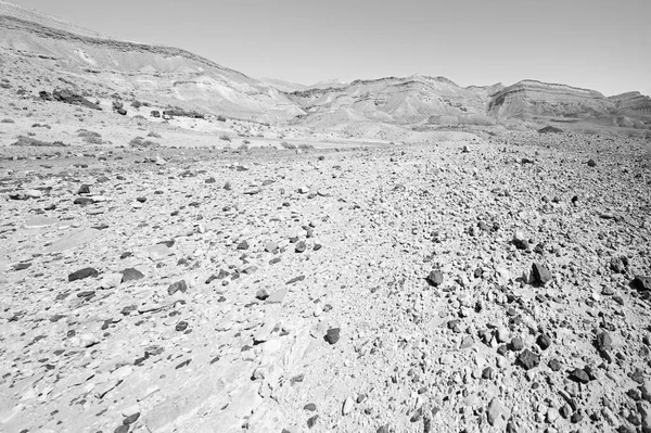 Lifeless and desolate scene of the breathtaking landscape of the rock formations in the Israel desert in black and white