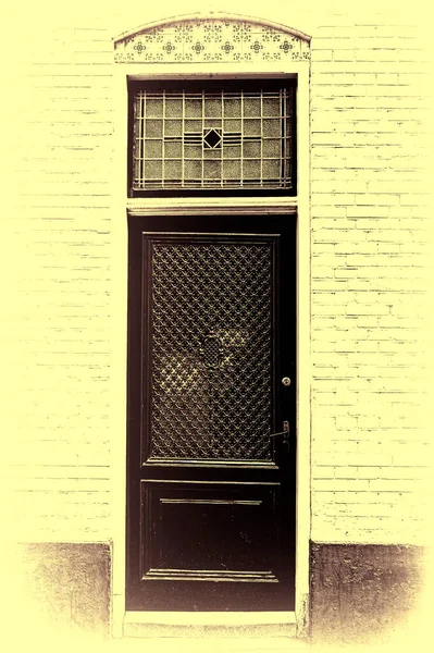 オランダ アムステルダムの伝統的な建築様式の建物に入り口のドア 白いレンガのファサードに艶をかけられたタイルでオランダの正面玄関 トーンのビンテージ スタイルの画像 — ストック写真
