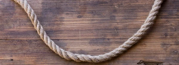 Tablero de madera con una textura áspera y una cuerda — Foto de Stock