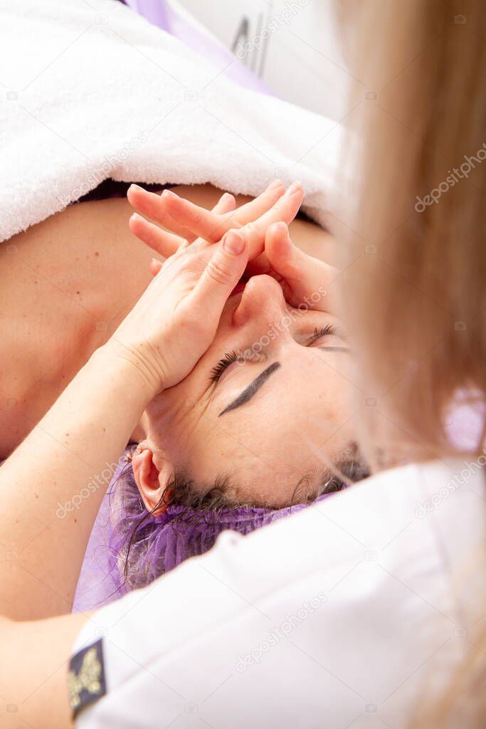 The specialist gives the girl massage and spa treatments for beauty and rejuvenation in the office