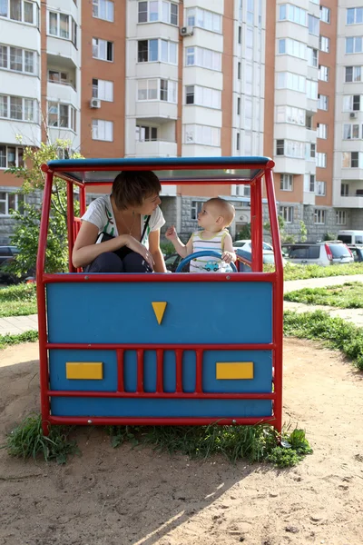 Mother and son in toy car — Stock Photo, Image