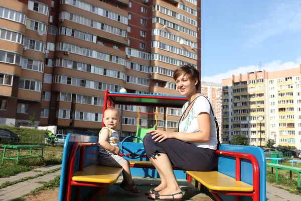 Mother and son sitting in toy car — Stock Photo, Image