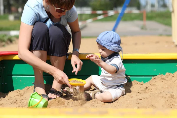 母亲和她的儿子筛沙子 — 图库照片