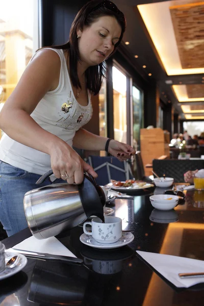 Woman pouring coffee — Stock Photo, Image