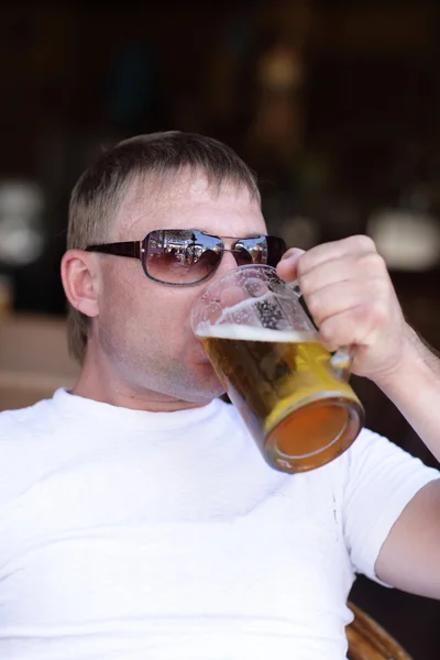Человек пьет холодное пиво — стоковое фото