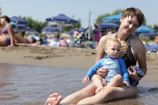 Mamma med barn på stranden — Stockfoto