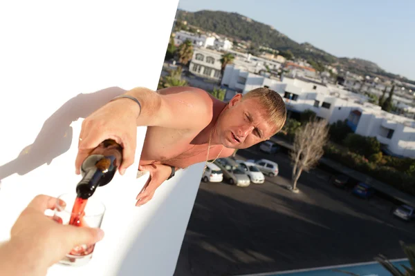 Homem derramando vinho na varanda — Fotografia de Stock
