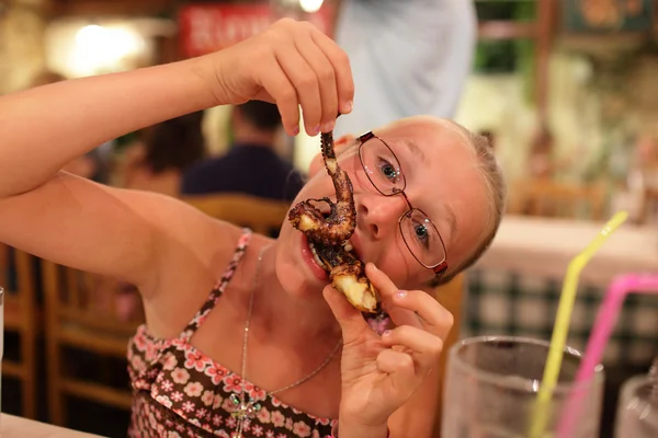 Chica comiendo pulpo — Foto de Stock