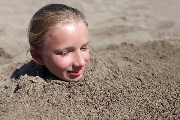 Kid zahrabaný v písku — Stock fotografie