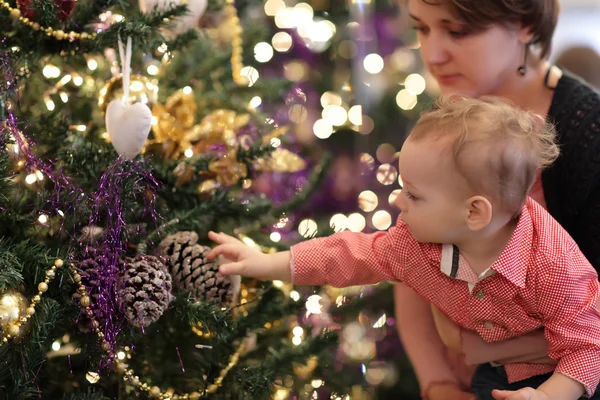 Baby touching Christmas tree — Stock Photo, Image