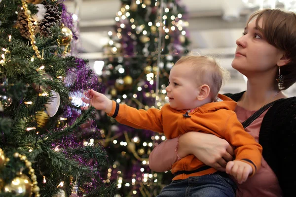 Mother with baby by Christmas tree — Stock Photo, Image