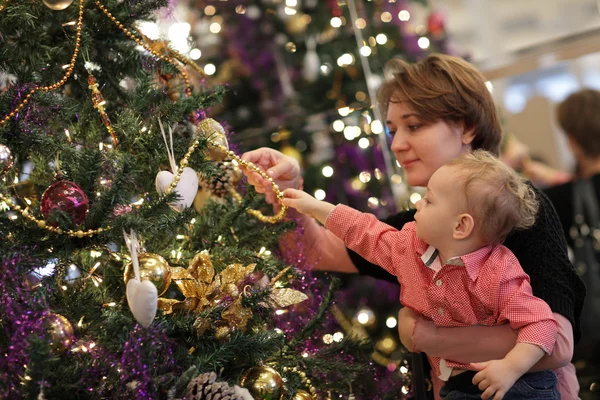 Moeder met baby in de buurt van de kerstboom — Stockfoto