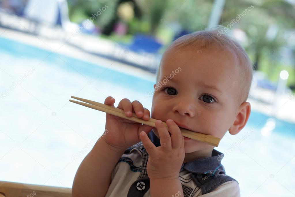 Baby biting chopsticks
