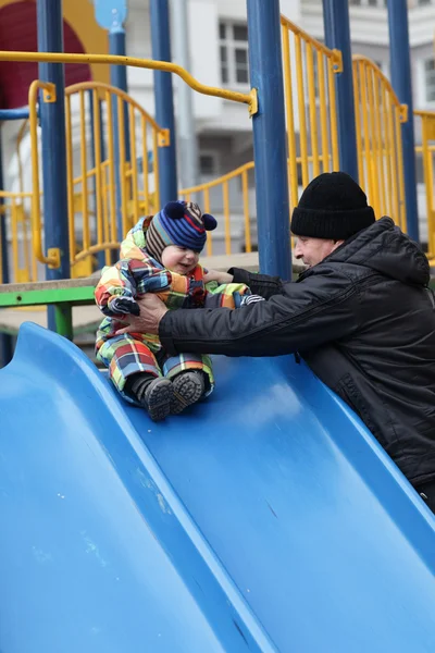 Grandfather and toddler on slide — Stock Photo, Image