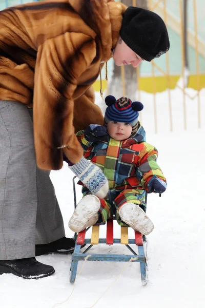 母はそりに幼児を置く — ストック写真