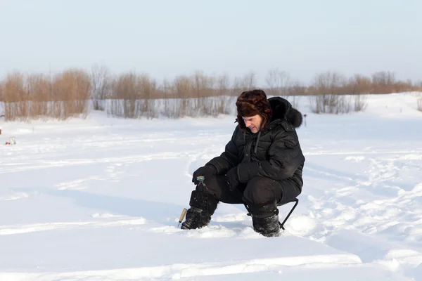 Winter fisherman sitting with fishing rod — Stock Photo, Image