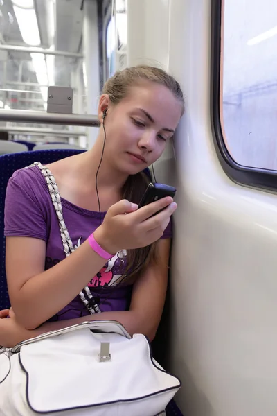 Girl listening music in train — Stock Photo, Image