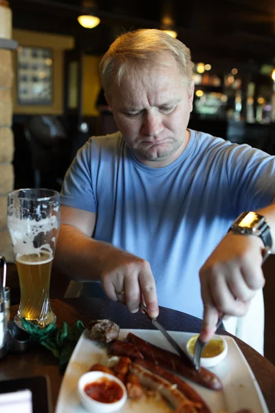 Man eating sausage — Stock Photo, Image