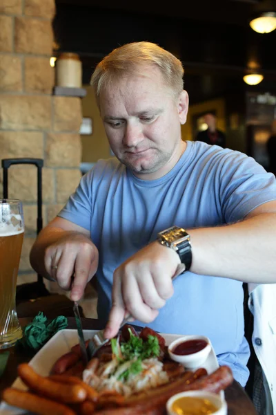 Man has sausage — Stock Photo, Image