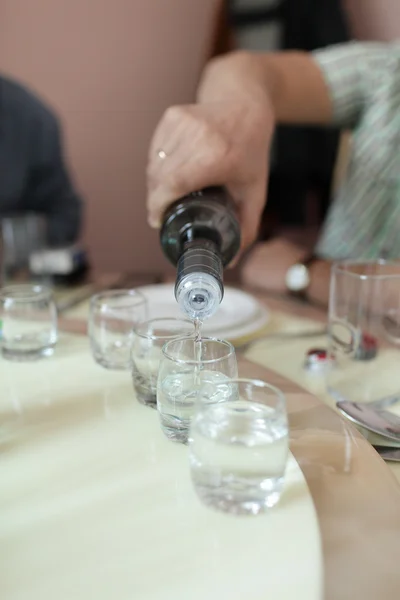Mann schenkt Wodka ein — Stockfoto