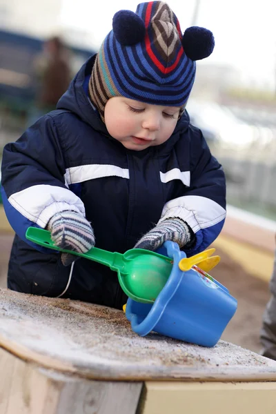 Toddler playing with shovel and bucket — Stock Photo, Image