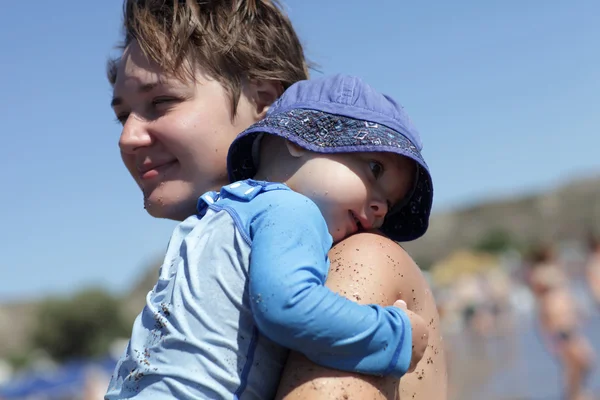 Matka trzyma jej maluch na plaży — Zdjęcie stockowe