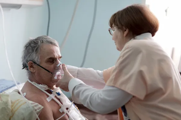 Nurse fixing oxygen mask — Stockfoto