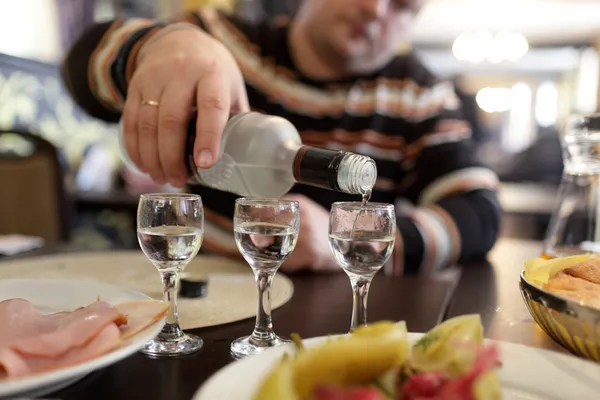 Taverna adam dökülen votka — Stok fotoğraf